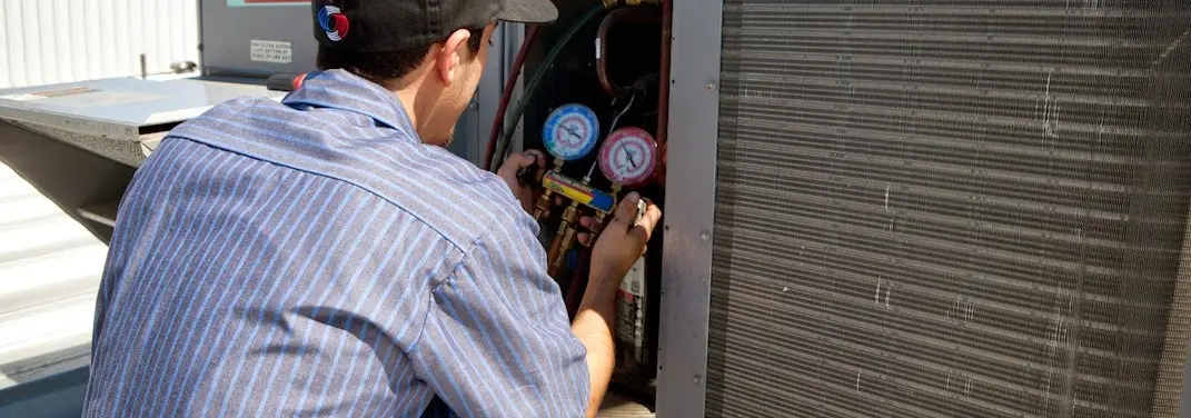 HVAC technician servicing a condenser unit in Ave Maria